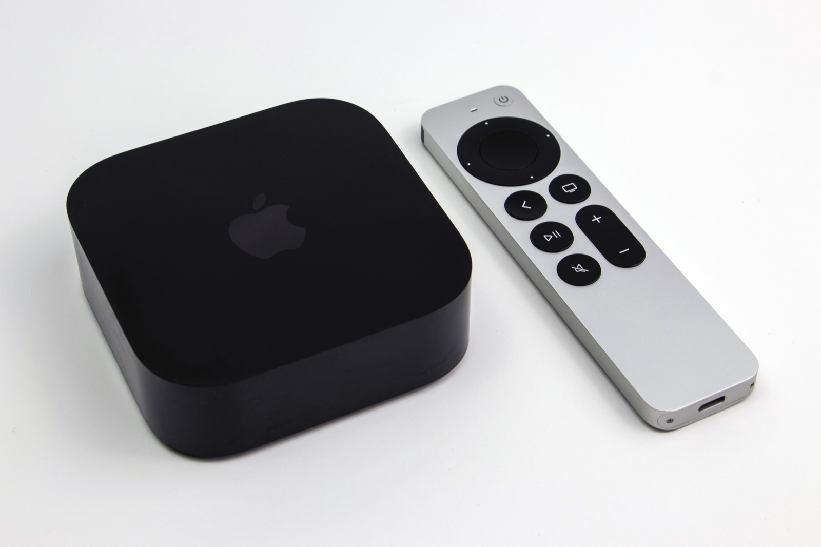 The black Apple TV 4K third generation box beside its silver Siri Remote with a USB-C port at the base