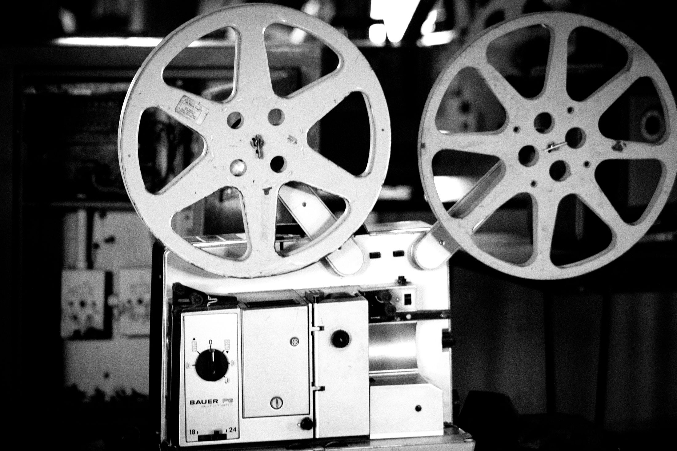 A black and white photograph of a vintage film projector and reels.