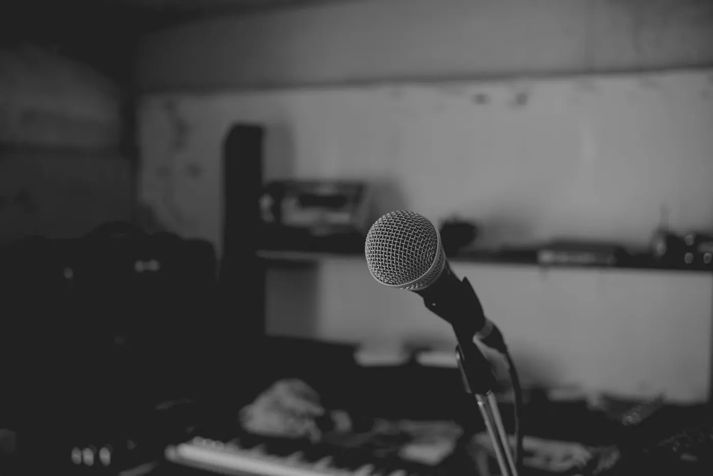 A microphone on a stand in a music room, in black and white.
